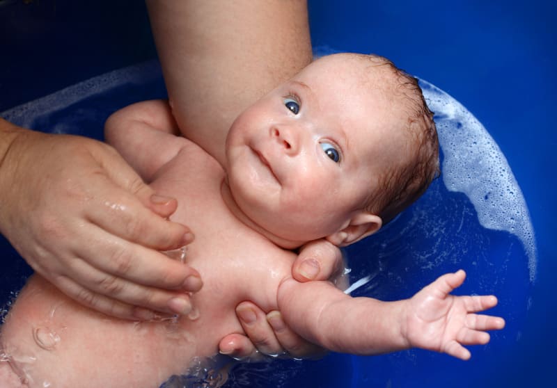 A baby getting a bath.