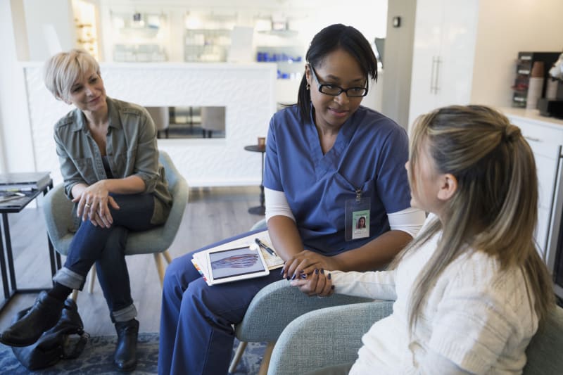 Doctor assuring teen girl about surgery.