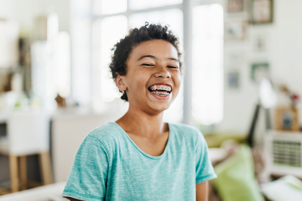 Teenage boy with braces laughing hysterically.