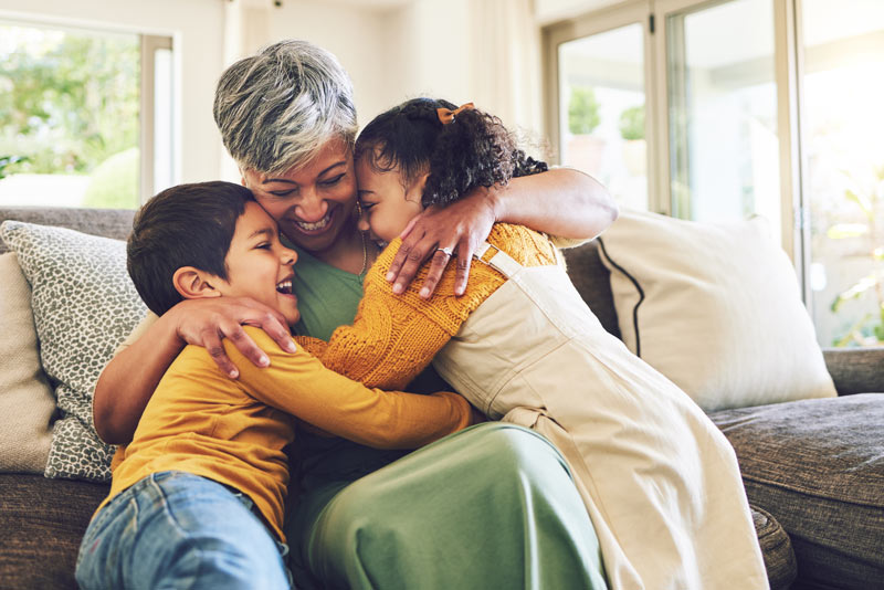 Hug, grandma or happy kids on a sofa with love enjoying quality bonding time together in family home. 